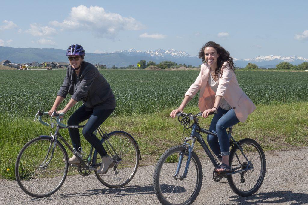 New staff members Dani Hess (Left) and Kelley Hall (Right) ride bikes outside WTI offices in Bozeman, MT