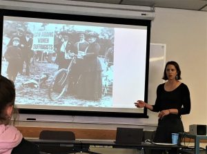 Dani Hess shows photos of women suffragettes during presentation on bicycle history