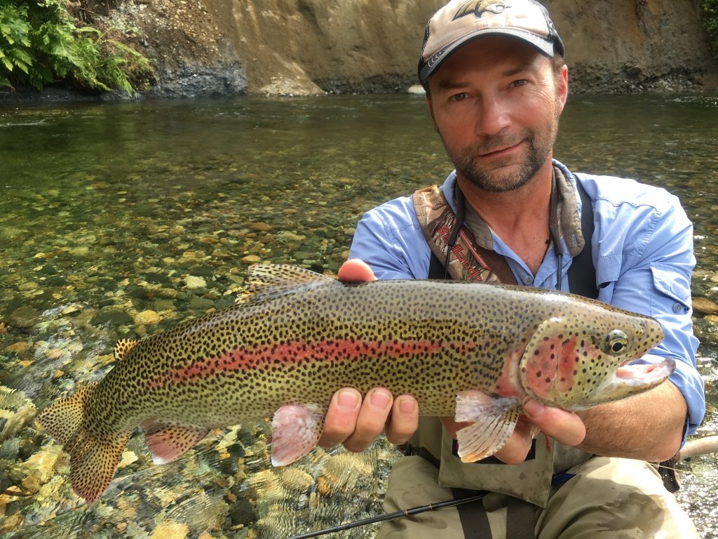 Matt Blank holding large fish near stream