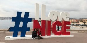 Annmarie McMahill and Jay Otto in front of a local welcome sign in Nice, France