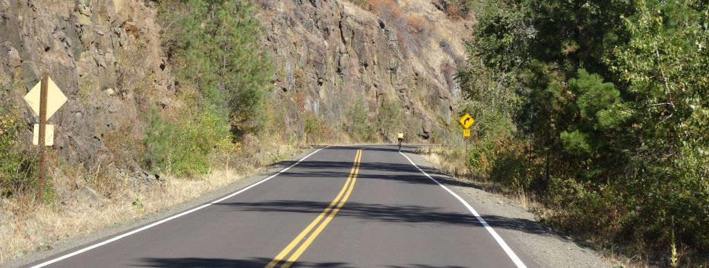 Cyclist travels along a curve on a mountainous highway