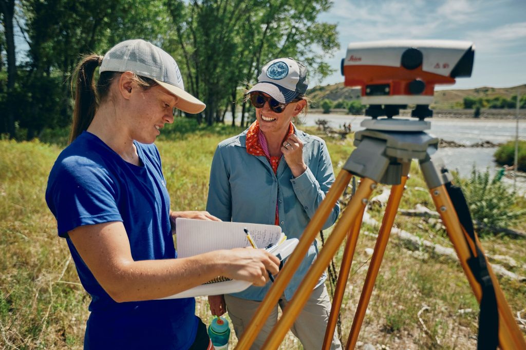 Haley Tupen and Katey Plymesser with monitoring equipment next to Yellowstone River