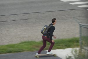 You adult using skateboard on sidewalk