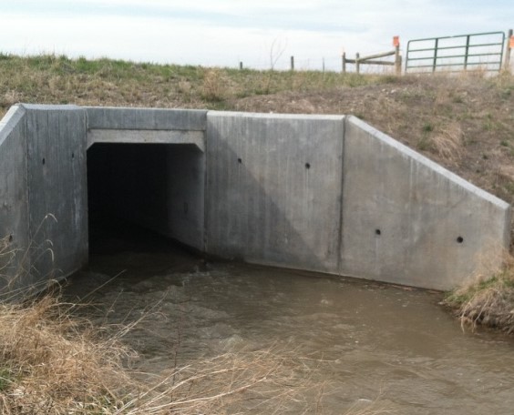 Culvert under a road with water passing through it