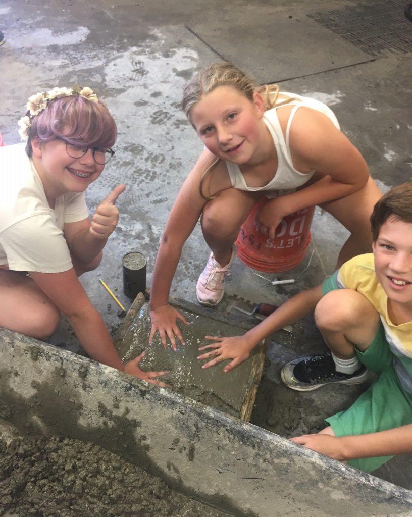 Students mix cement at transportation camp 2019